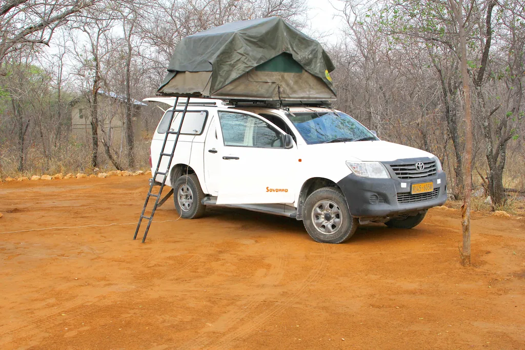 Toyota Hilux mit Dachzelt auf einem Campingplatz im Onguma Naturreservat